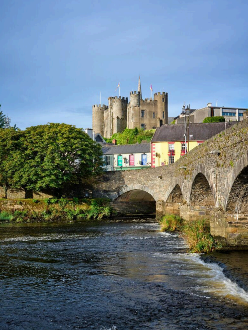 A view of the Norman Enniscorthy Castle from below the bridge. The River Slaney is in the foreground of the image with an old bridge to the right