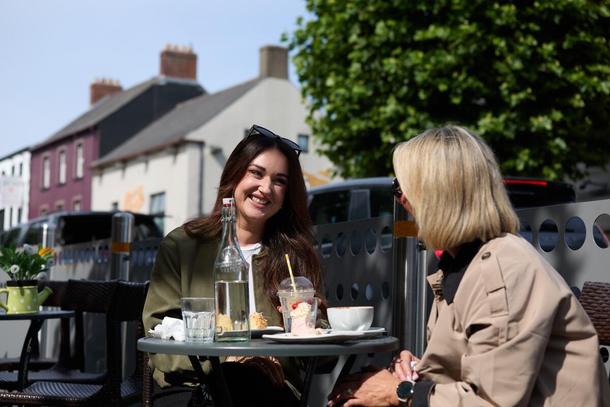 2 ladies having lunch at an outdoor table on the main street