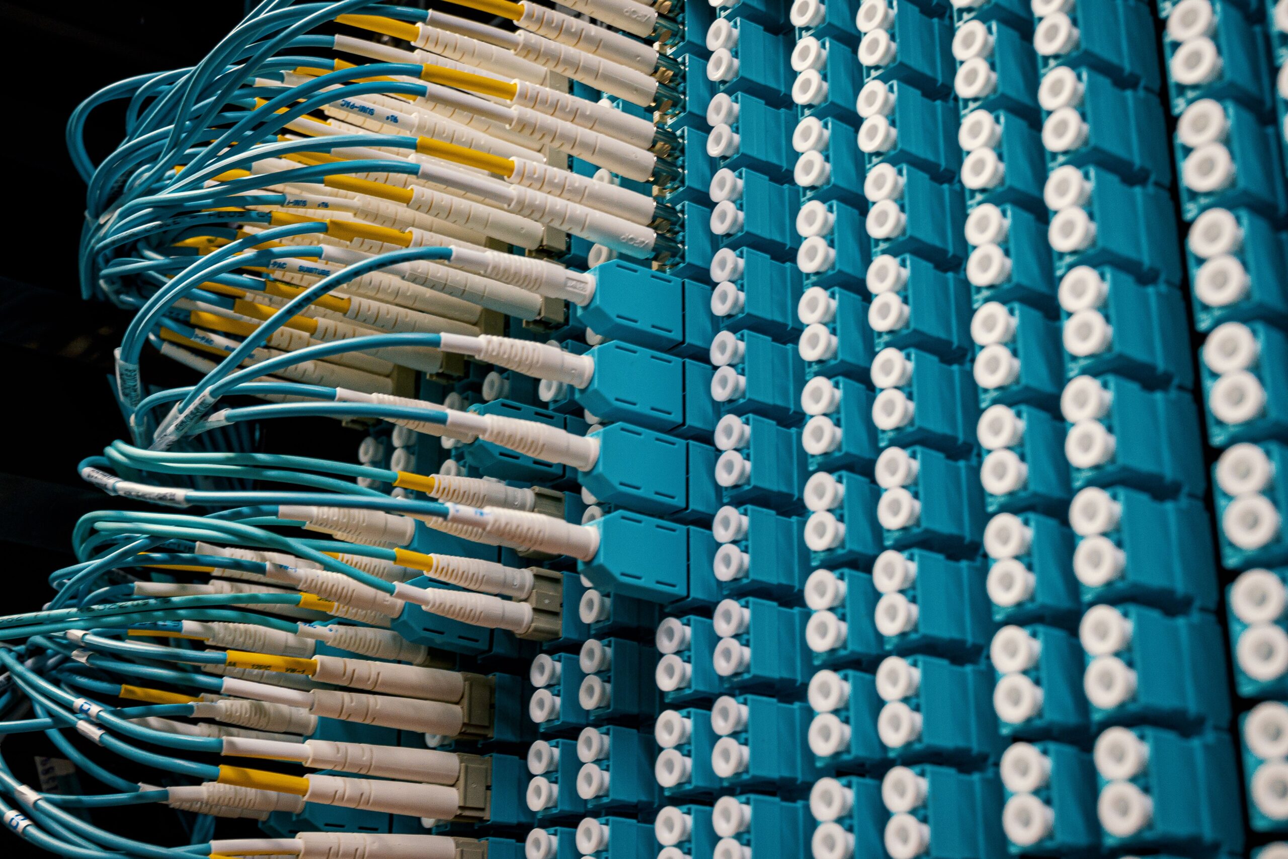 Detailed view of fibre optic cables connected in a data centre rack, showcasing modern networking technology