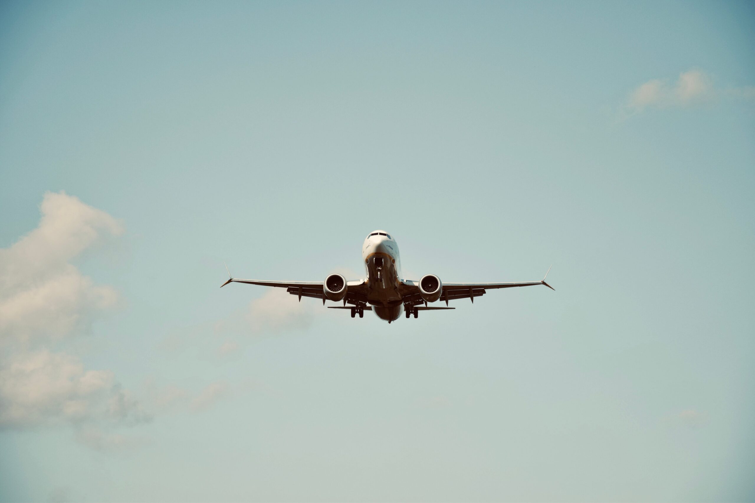 A commercial airplane in flight against a clear blue sky