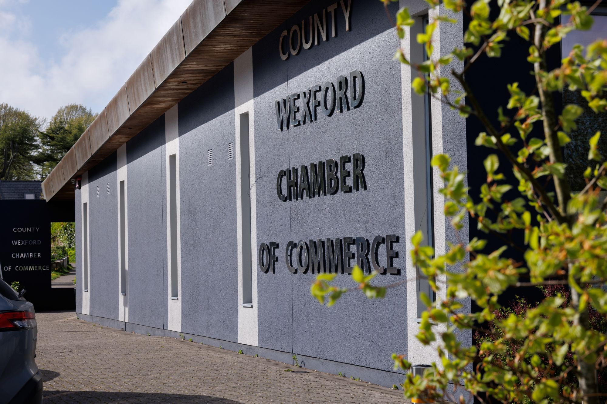 Side view of the Wexford Chamber of Commerce building. Grey building with the name in mirrored letters