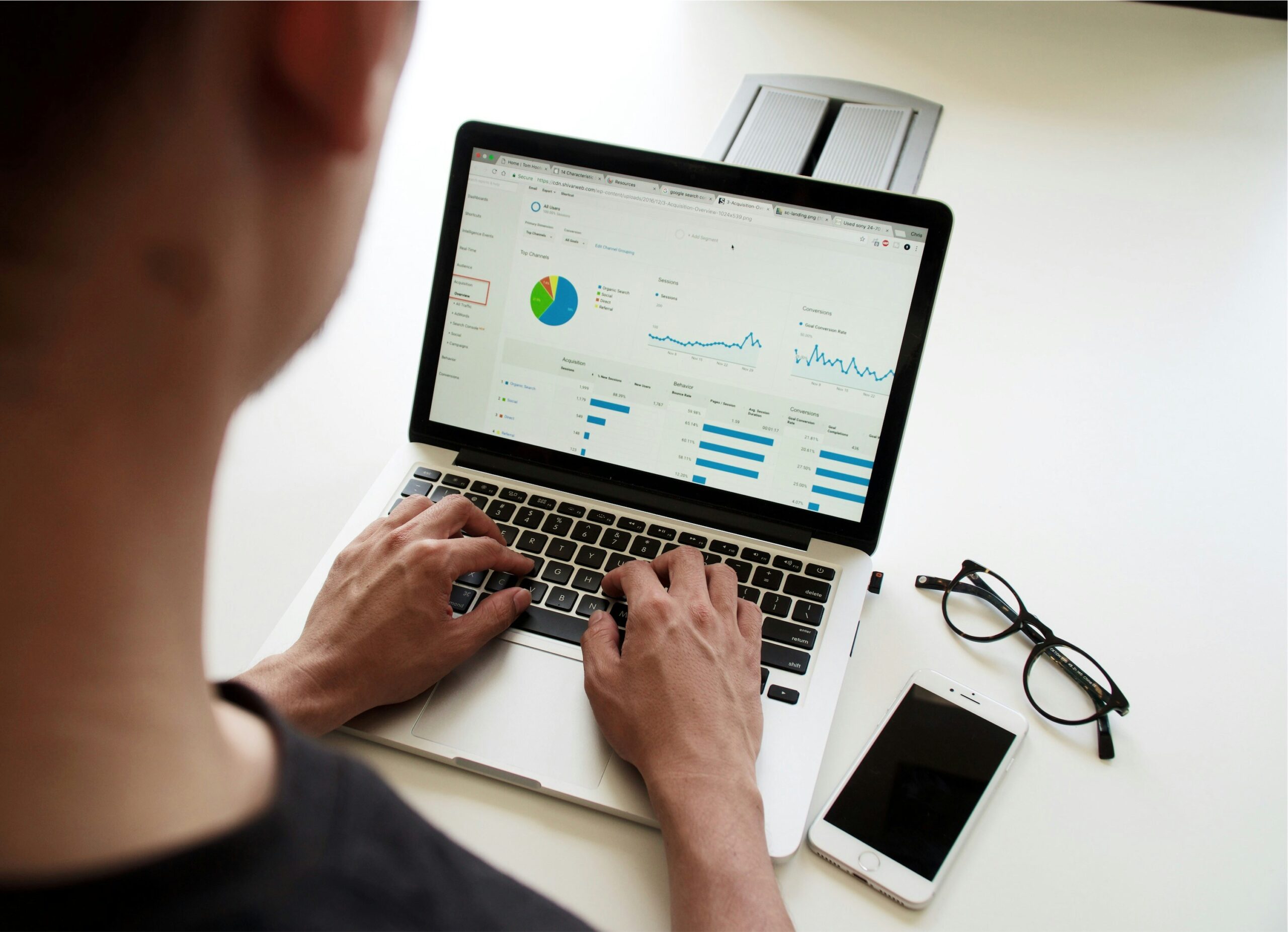 Person working on a laptop, looking at pie charts