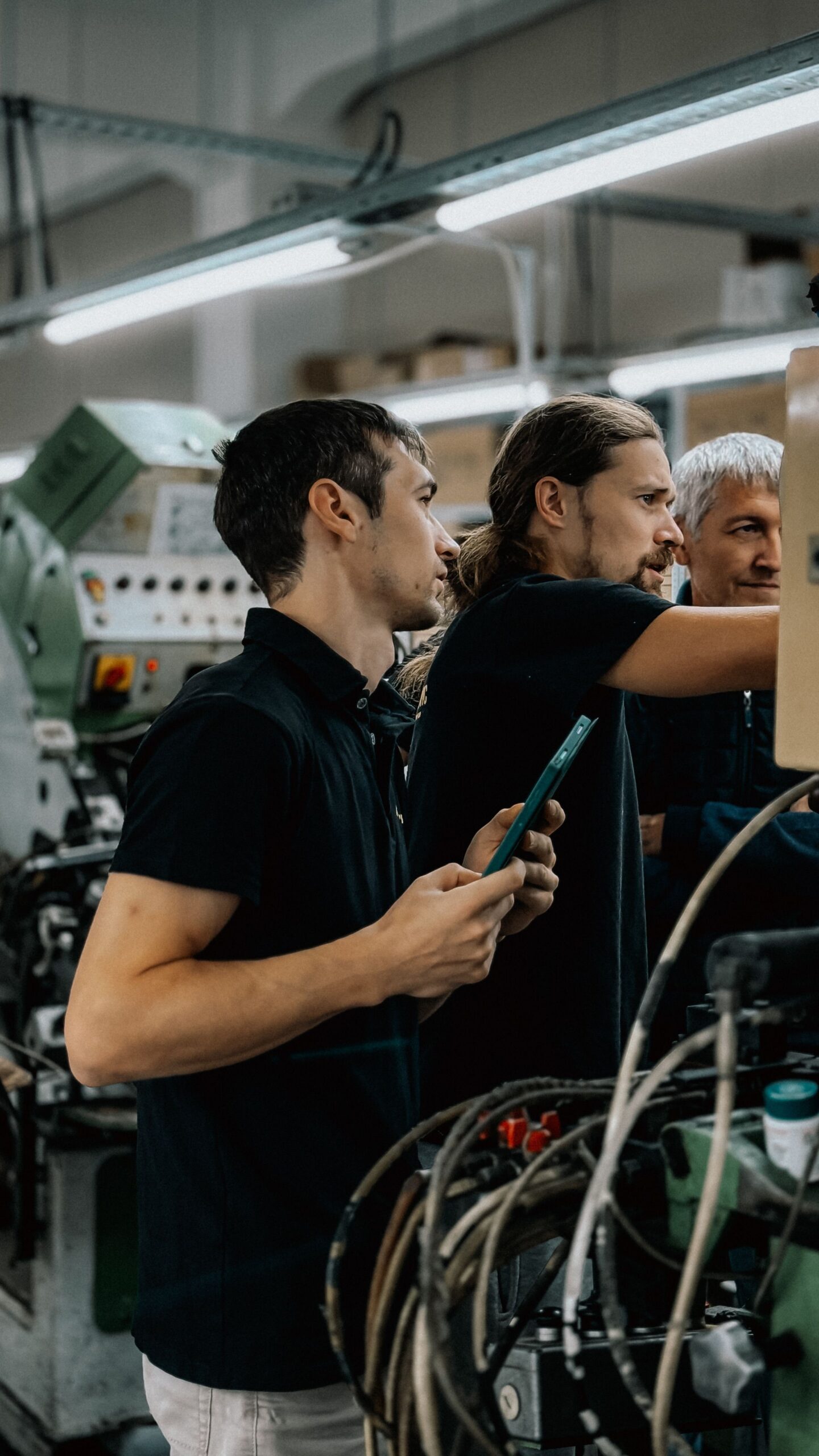 Engineers collaborating in an advanced manufacturing facility, focusing on machinery operations