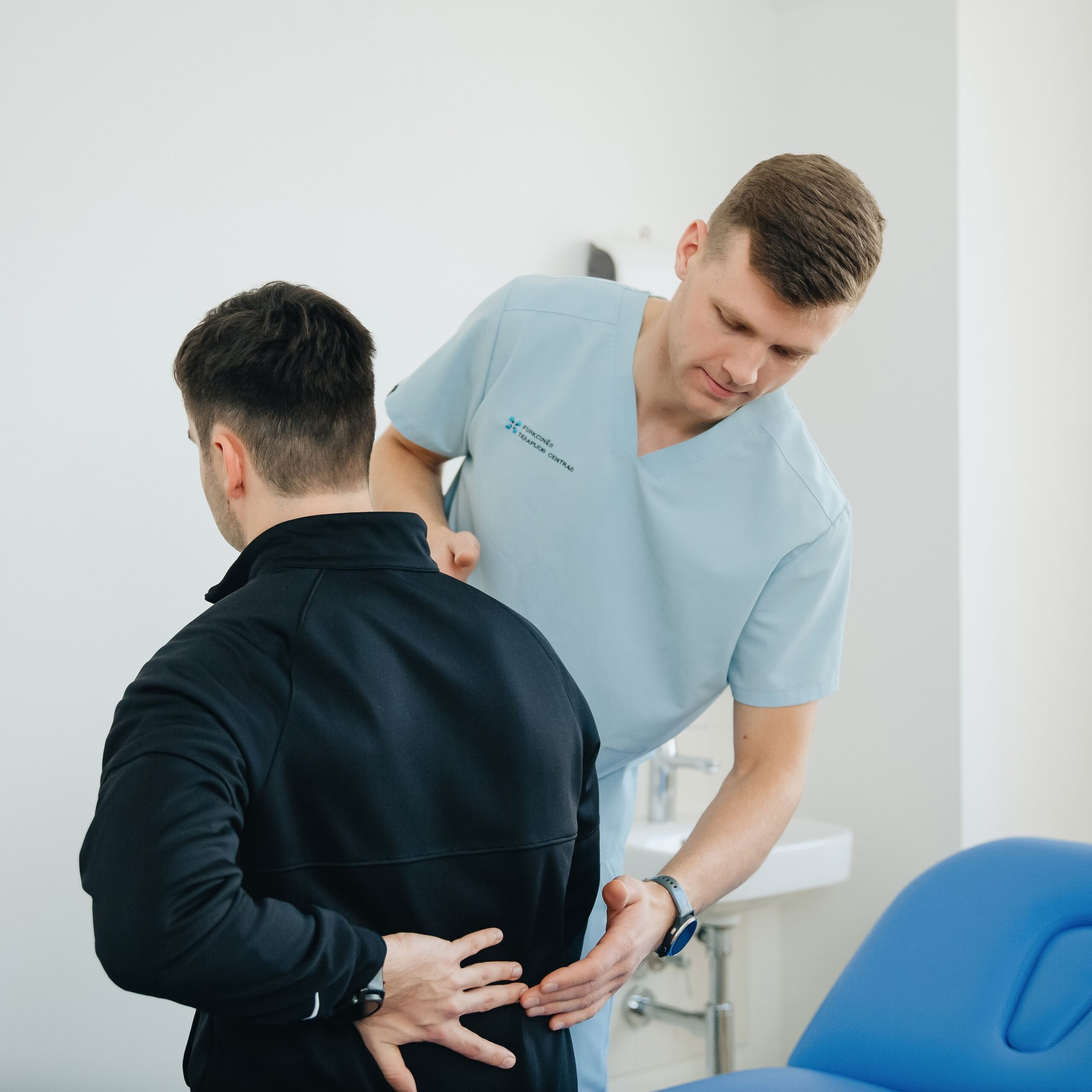 A physio helps a patient with back issues